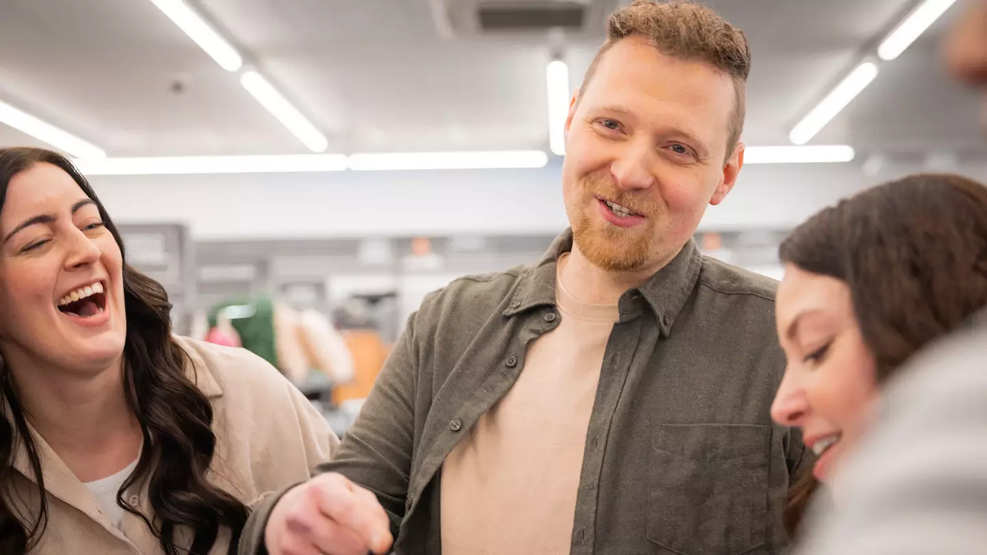 Zaměstnanci se společně smějí při týmovém rozhovoru na prodejní ploše.